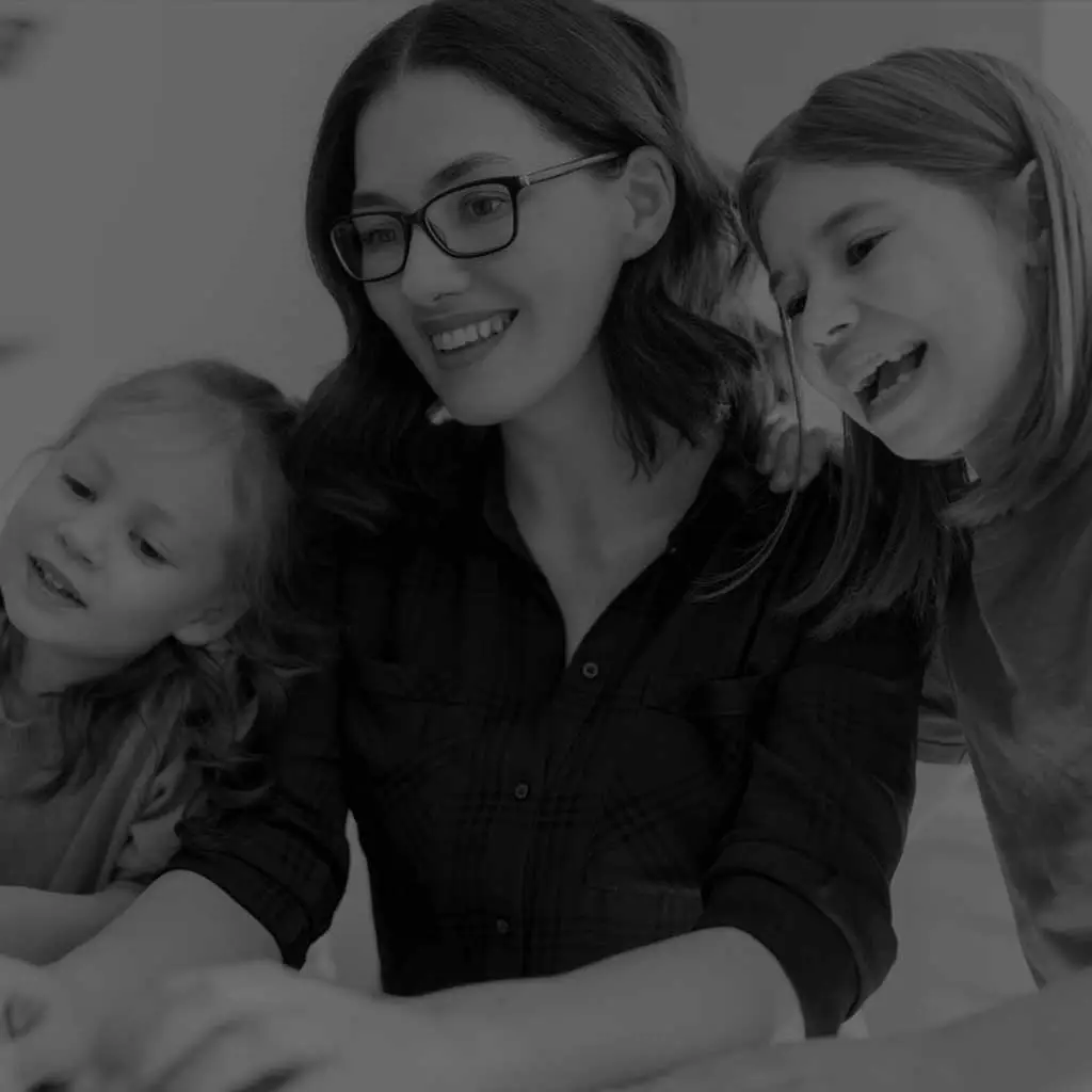 Family looking and smiling at a computer learning about cyberguard families