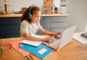 Child education, learning and listening with laptop and headphones for an online interactive activi