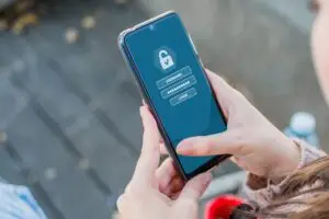 Closeup of a person holding a smartphone with a security app on it - concept of cybersecuri